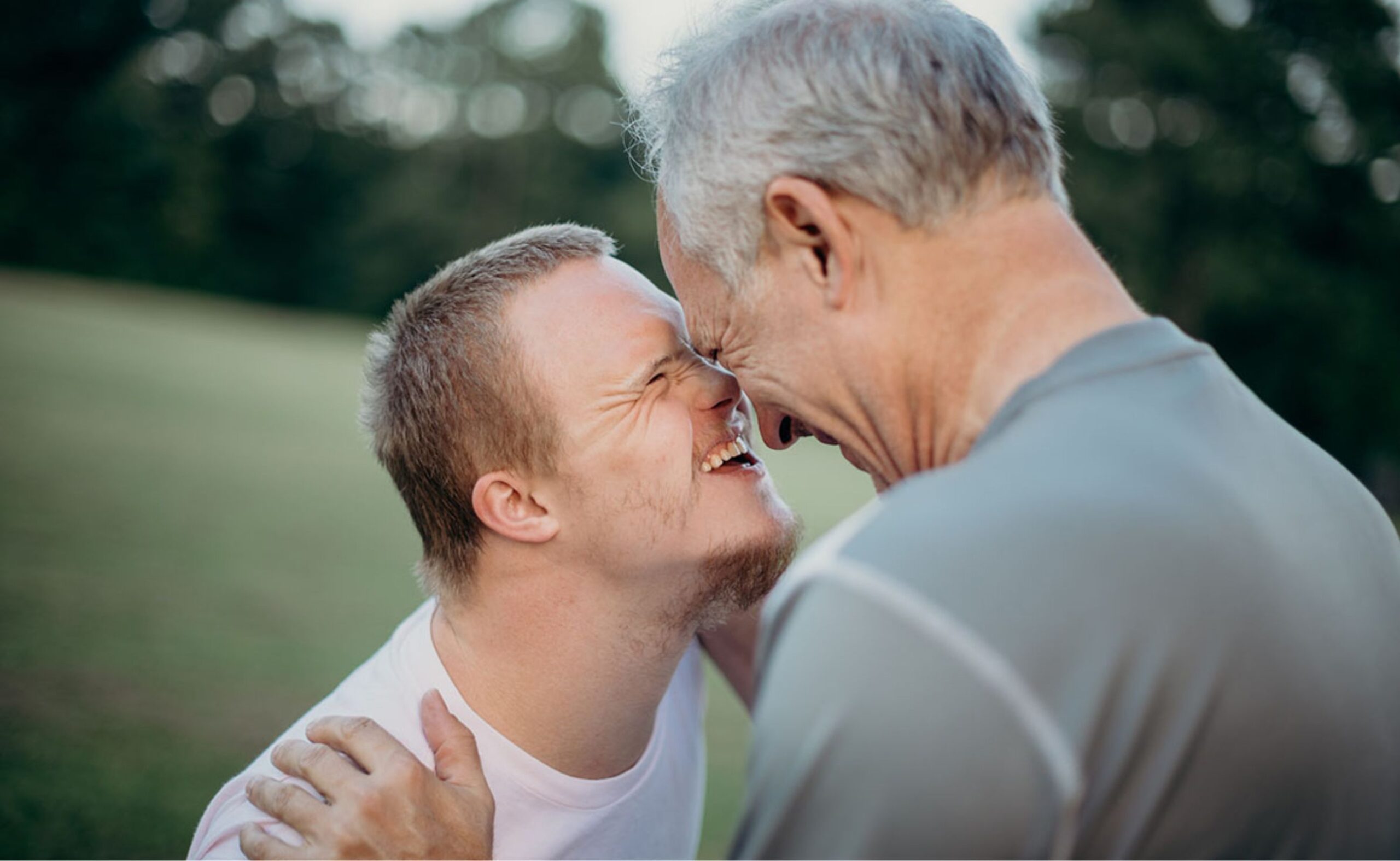 Young adult male with down syndrome embracing his father