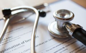 Clipboard with form for government benefits and a stethoscope laying on top. 