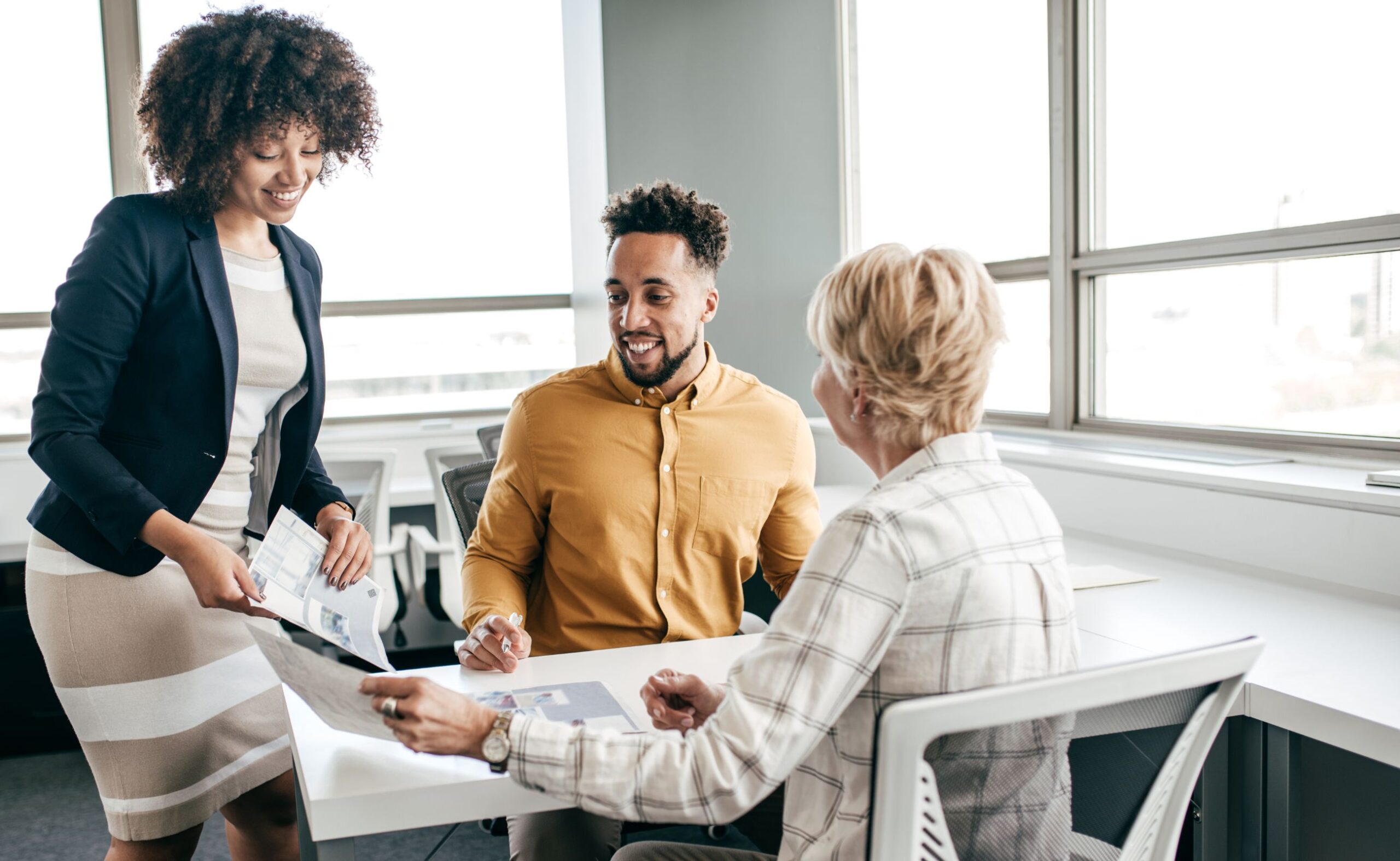 three business people sitting at a table in an office